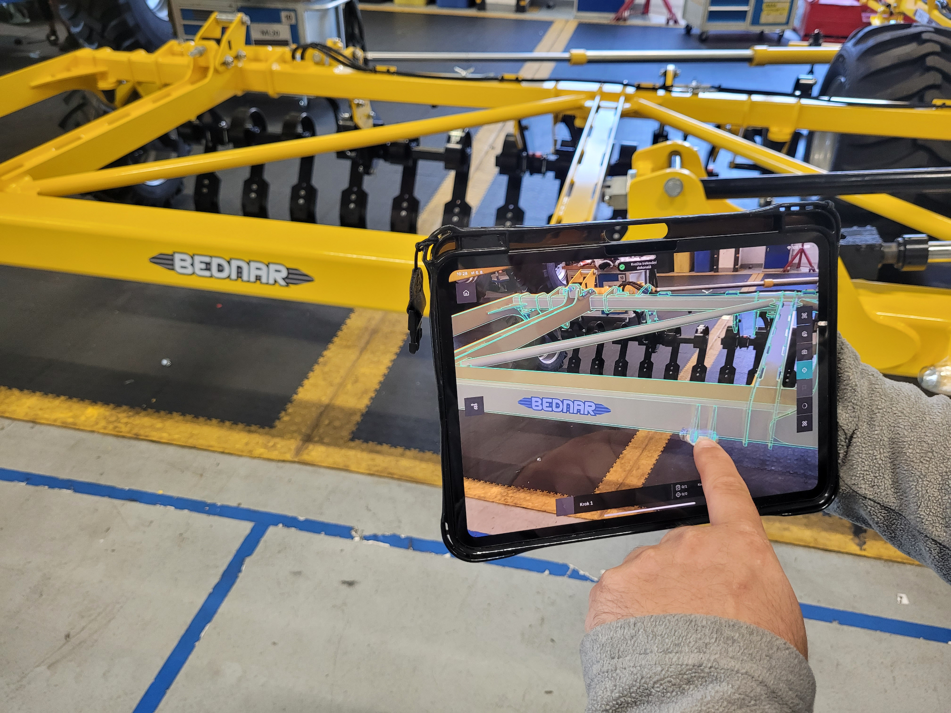 Operátor s tabletem kontroluje kvalitu komponentu pomocí AR overlay 3D modelu